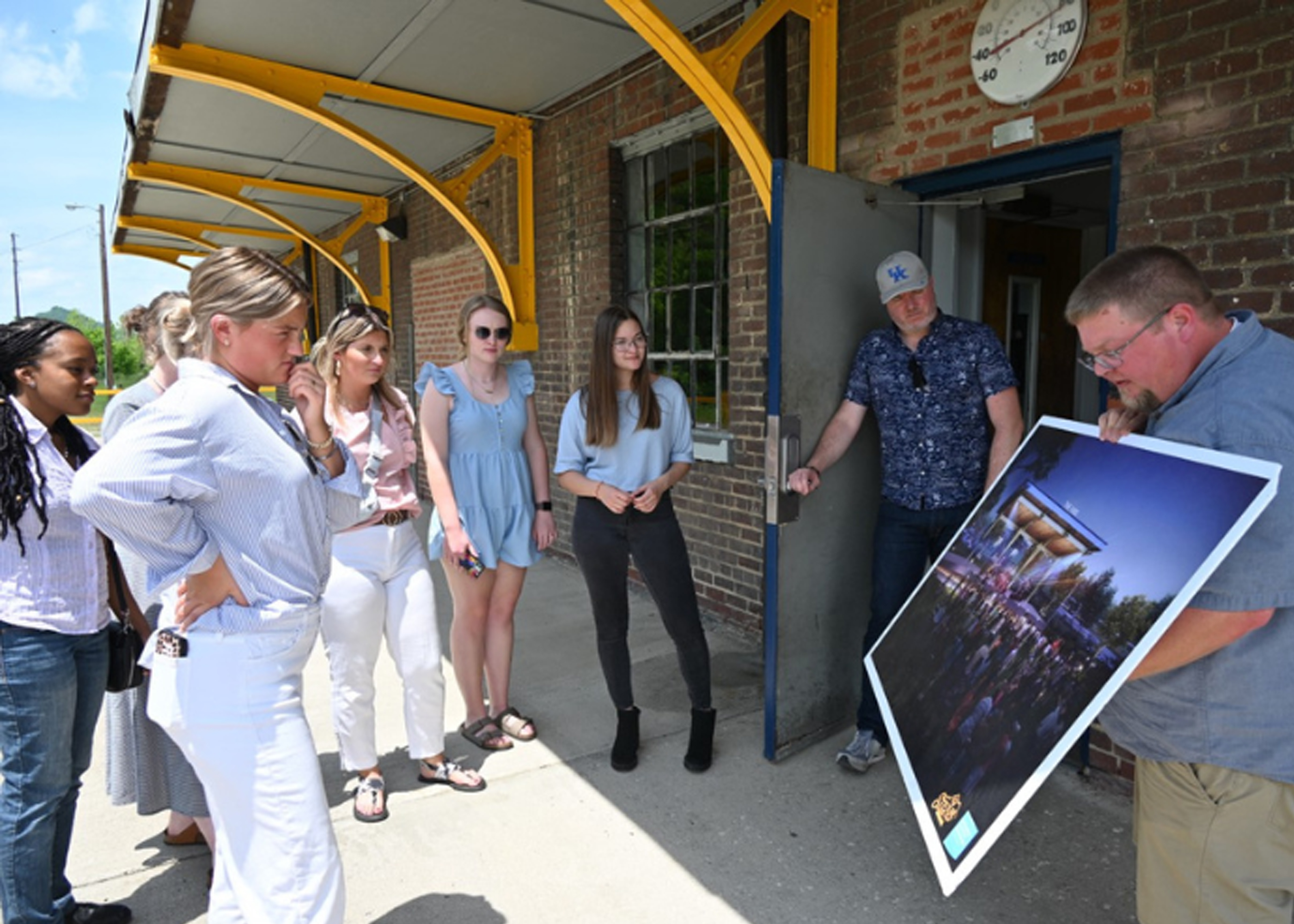 Photograph of student interns looking at information with community member.