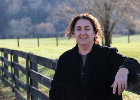 Photograph of Carolina Segura outside by a horse fence